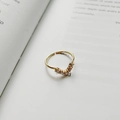 Verstellbarer goldener V-Ring mit Zirkonia-Steinen auf einem offenen Vintage-Buch - J-749 Chevron Zirkonia Ring / 18K Gold