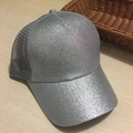 Macro detail of a silver sequined baseball cap with gray mesh back on a wooden table - Silver