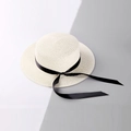 Dettaglio della trama in paglia intrecciata e del nastro di seta nera sul cappello beige - Bambini / Bianco Latte