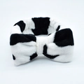 Soft coral fleece headband with a large black and white cow print bow and elastic band - Black and White Cow
