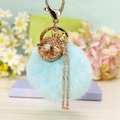 Porte-clés avec pompon en peluche bleu et boule en métal évidée dorée pour sacs - Emballage unique en sac OPP / Bleu Ciel