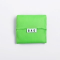 Foldable neon green Oxford cloth shopping bag in square folded state with BAG label - Green