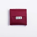 Foldable burgundy shopping bag in square pouch form with a minimalist BAG textile label - Burgundy