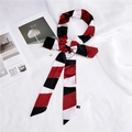 Polka dot skinny silk scarf in red and black stripes tied in a bow on a magazine - Red Geometric Stripe