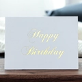 Weiße Geburtstagskarte aus Karton mit eleganter Goldfolien-Prägung auf einem Holztisch - Alles Gute zum Geburtstag Bronzierte Grußkarte (371-G)