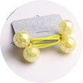 Macro view of a yellow elastic hair band with four large glitter resin beads on card - Yellow