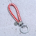Detailed view of red and white braided leather keychain with polished silver metal ring - Red & White