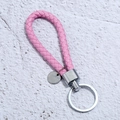 Close-up of pink braided leather keychain with silver metal ring and blank tag - Pink