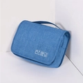Closed blue travel toiletry bag made of textured fabric with a convenient top handle - Sky Blue