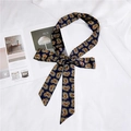 Blue skinny silk scarf with yellow and red paisley pattern tied in a bow on white - Paisley Navy
