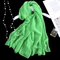 Elegant emerald green long silk scarf hanging gracefully against a dark luxury background - Verdant