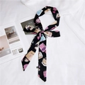 Narrow black silk scarf featuring white perfume bottle prints tied over a magazine - Perfume Black