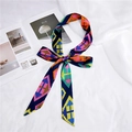 Close-up of geometric patterned narrow silk ribbon tied in a bow on a lifestyle background - Colorful Arrows