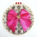 Detail of rose pink satin bow accessory featuring a square yellow crystal center on straw mat - Rose Red