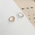 Minimalistische Herzschlag-Ringe in Gold und Silber auf dekorativem Hintergrund-Design - Gold