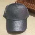 Detail of silver sequin trucker hat with grey breathable mesh back on wood surface - Dark Gray