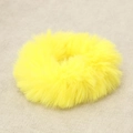 Furry yellow scrunchie with soft plush texture shown on a neutral linen background - Yellow
