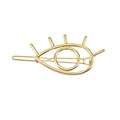 Macro shot of a golden metal eye-shaped hair clip featuring detailed eyelash accents - Gold Evil Eye
