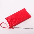 Glossy bright red crocodile embossed clutch bag with wrist strap and gold zipper closure - Red