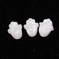 Macro shot of 1.8mm white synthetic opal Hamsa hand beads on black velvet base - Light Pink