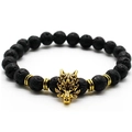 Men's black lava rock bead bracelet with golden dragon head charm on white background - Lava Stone / Gold