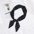 Narrow black neck scarf with gold geometric patterns and a knot on a fashion magazine - 30 Small Squares Black