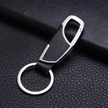 Creative silver metal and black faux leather car keychain displayed on a leather background - Silver Style (GD-345)