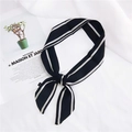 Sciarpa di seta nera a righe bianche annodata a fiocco su sfondo lifestyle elegante - 15 Linea Singola Verticale Nero