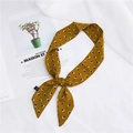 Elegant yellow silk scarf with red square pattern tied in a bow on a magazine - 17 Small Squares Yellow