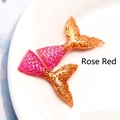 Macro detail of resin mermaid tail charms with pink to gold gradient and glitter - Rose Red