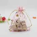 Detail of pink organza gift bag featuring gold stamped hearts and drawstring closure - Pink