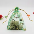 Green organza gift bag with gold heart patterns and golden drawstring closure - Dark Green