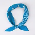 Blue square silk scarf featuring white paisley patterns tied in a decorative knot - Paisley Peacock Blue
