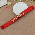 Red elastic waist belt for women with golden filigree buckle on a textured background - Red / 65cm