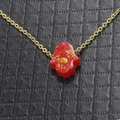 Makroaufnahme des roten Glitzer-Hamsa-Handanhängers an einer Goldhalskette - Rot