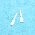 Detail of two white plastic miniature anchors for DIY phone case decoration on blue sand - White Paddle