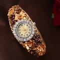 Detail of luxury gold floral bangle watch with rhinestones on silk fabric - Champagne/Gold