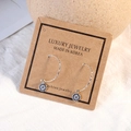 Silver devil eye earrings with micro-inlaid rhinestones on a craft card display - White Gold (ED559)