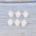 Close-up of white Hamsa beads with glitter effect on blue wood texture background - White