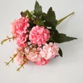 Detailed view of artificial pink hydrangea bouquet with green leaves on white background - Pink