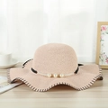 Elegant wide brim straw sun hat in peach with pearl ribbon and black wavy edges - Lotus Pink