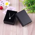 Joyero negro vintage de papel kraft con collar de perlas plateadas sobre madera - 7x9x3cm / Negro