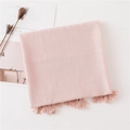 Flat lay of pink cotton linen scarf with elegant tassels on a minimalist background - Pink