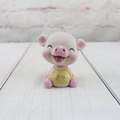 Detailaufnahme einer rosa Schweinefigur aus Harz mit goldener Glücksaufschrift - Blinzelnd - Glück
