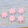 Primo piano di stelle di David in opale sintetico rosa con riflessi multicolore - Rosa