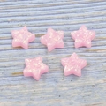 Macro shot of five-pointed star synthetic pink opal stones with iridescent shimmer texture - Pink