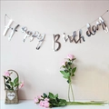 Silver glittery Happy Birthday banner with metallic wave texture on beige wall - Silver HAPPY BIRTHDAY Banner