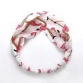 Elastic twist headband featuring a pink flamingo print on a clean white fabric base - White Bird
