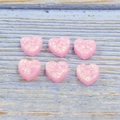 Close-up of pink heart-shaped resin charms with glitter effect for DIY jewelry making - Pink