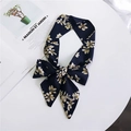Dark blue silk neck scarf with beige floral pattern tied on a white surface - Navy White Magnolia